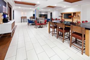 克洛维斯克洛维斯弗雷斯诺地区智选假日酒店及套房的开放式的用餐室配有桌椅