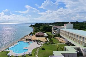 石垣岛Beach Hotel Sunshine Ishigakijima的享有带游泳池和海洋的度假村的空中景致