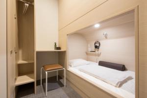 福冈Grand Cabin Tenjin Minami的一间小卧室,配有一张床和一把椅子