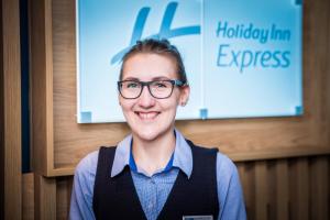 埃克塞特Holiday Inn Express - Exeter - City Centre, an IHG Hotel的戴眼镜的女人站在标志前