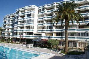 英格兰海滩Apartamentos Teror - Gavias del Sol的一座棕榈树和游泳池的建筑
