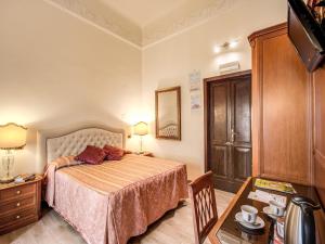 罗马拉贝勒酒店的一间卧室配有一张床、梳妆台和桌子