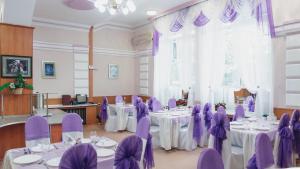 阿克托比Aktobe Hotel的配有桌椅和紫色椅子的房间