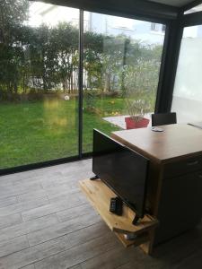 佩萨克La KLEMALINE的办公室设有一张桌子、一台电视和一个窗口