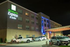 代顿Holiday Inn Express & Suites - Dayton Southwest, an IHG Hotel的停车场内有车辆的旅馆
