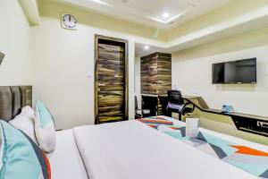 艾哈迈达巴德Hotel Palliate Ellisbridge的一间卧室配有一张床、一张书桌和一台电视。