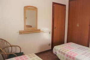 托里代巴拉拉磨家蒙特科所公寓的一间卧室配有镜子、一张床和一把椅子