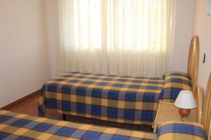 托里代巴拉拉磨家蒙特科所公寓的一间卧室配有一张带铺着地毯的床和窗户。