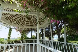 蒙特哥贝Holiday Inn Resort Montego Bay All-Inclusive, an IHG Hotel的白色凉亭,房子上放着粉红色的花