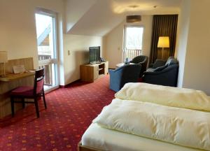 罗迪斯海恩沃尔夫斯穆尔菲林酒店的酒店客房,配有一张床、一张桌子和椅子