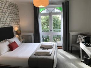 布莱顿霍夫白屋旅馆的一间卧室设有一张大床和一个窗户。