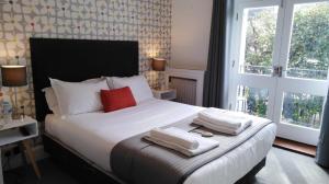布莱顿霍夫白屋旅馆的一间卧室配有一张大床和毛巾