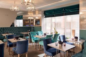 圣彼得堡巴尔提亚酒店的餐厅设有木桌和蓝色椅子