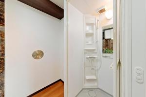 东京Terrace Terano#201的一间小浴室,拥有白色的墙壁和白色的架子