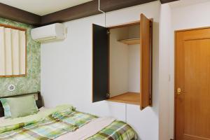 东京Terrace Terano#201的一间带床和橱柜的小卧室
