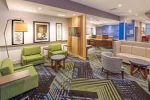 WhitestownHoliday Inn Express & Suites - Indianapolis NW - Zionsville, an IHG Hotel的大堂设有桌椅和等候室