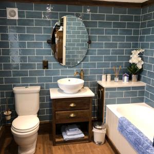 StoneColdharbour Cottage的一间带卫生间、水槽和镜子的浴室