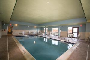 柯克斯维尔Holiday Inn Express & Suites - Kirksville - University Area, an IHG Hotel的一个带桌椅的大型游泳池
