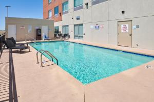埃尔帕索Holiday Inn Express & Suites El Paso East-Loop 375, an IHG Hotel的一座建筑物中央的游泳池