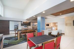 法兰克福法兰克福智选假日套房酒店的开放式厨房以及带桌椅的用餐室。