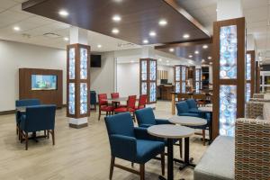 West PlainsHoliday Inn Express & Suites West Plains Southwest, an IHG Hotel的一间设有蓝色桌椅和桌面的等候室