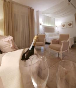 卢切拉Le Nicchie Guest House的一间提供一瓶香槟和两杯葡萄酒的房间