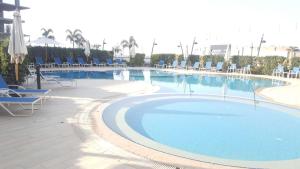开罗The Resort Chalet- Porto New Cairo的一个带蓝色椅子的大型游泳池和一个游泳池