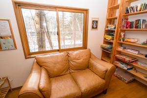 轻井泽Guest House Chaconne Karuizawa的客厅设有真皮沙发,配有窗户
