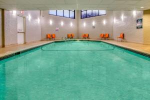 布卢明顿明尼阿波利斯布卢明顿西区拉昆塔套房酒店的一座大型游泳池,里面设有橙色椅子