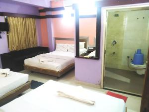 科鲁鲁Abimon Residency Kollur的客房设有两张床、镜子和卫生间
