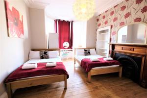 爱丁堡巴尔莫尔宾馆的一间卧室设有两张床、一个壁炉和一个吊灯。