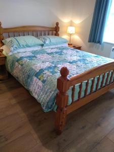 梅布尔索普Rosedene的一间卧室配有一张带木制床架的床