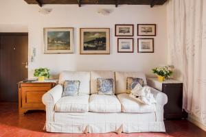 罗马Coronari Suite的客厅配有白色沙发,墙上挂有图片