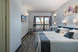 大加那利岛拉斯帕尔马斯科隆海滩公寓的酒店客房设有两张床和一个阳台。