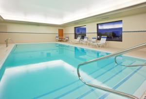 贝城贝城快捷假日&套房酒店的蓝色的大游泳池,位于酒店客房内
