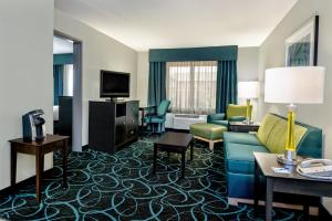 沃思堡Holiday Inn Express Hotel and Suites Fort Worth/I-20的酒店客房设有沙发、椅子和电视。