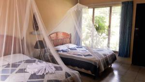 蒂卡尔Hotel Tikal Inn的一间卧室配有一张带蚊帐的床