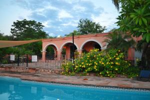 阿拉莫斯Loma de Guadalupe Alamos Sonora的一座带游泳池的建筑,旁边是鲜花