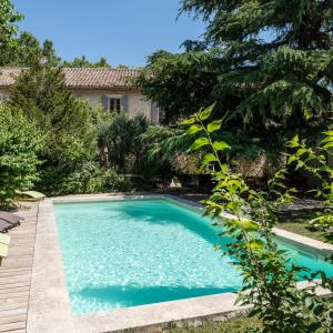 Saint-Étienne-du-GrèsHôtel Mas Vidau Porte des Alpilles的一座房子的院子内的游泳池