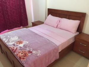 拉巴特ocean view apartment的一间卧室配有一张带粉色床单和粉色毯子的床。