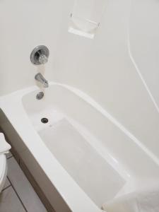 萨利纳萨利纳价值套房酒店的浴室内设有带水槽的白色浴缸