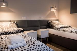 皮瑟兹诺Apartament Centrum XL - Komfortowe Noclegi的一间设有两张床和两个床头柜的房间