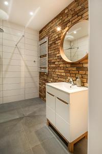 皮瑟兹诺Apartament Centrum XL - Komfortowe Noclegi的浴室设有白色水槽和镜子