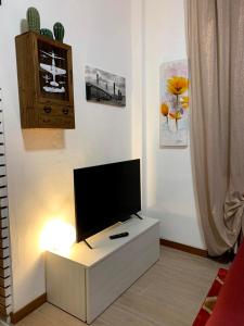 帕代诺杜尼亚诺Appartamento “La Corte”的客厅配有白色橱柜上的平面电视