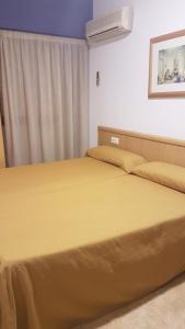 厄尔·阿尔特阿尔特旅馆的一间卧室配有一张带黄色床单的床和一扇窗户。