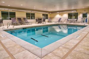 克莱尔莫尔Holiday Inn Express & Suites Tulsa NE, Claremore, an IHG Hotel的一个带桌椅的大型游泳池