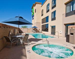 奥罗谷Holiday Inn Express & Suites Oro Valley-Tucson North, an IHG Hotel的大楼旁的热水浴池配有桌椅