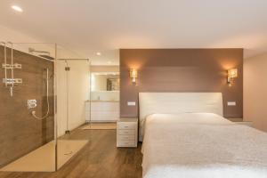 杜基拉特Apartment TESI的一间卧室设有一张床和一个玻璃淋浴间