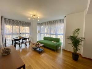瓦伦西亚Beach Luxury Apartment的客厅配有绿色沙发和桌子