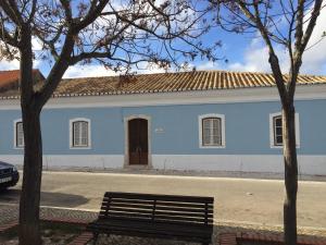 阿尔沃尔Casa Largo do Poço Guesthouse的前面有长凳的蓝色建筑